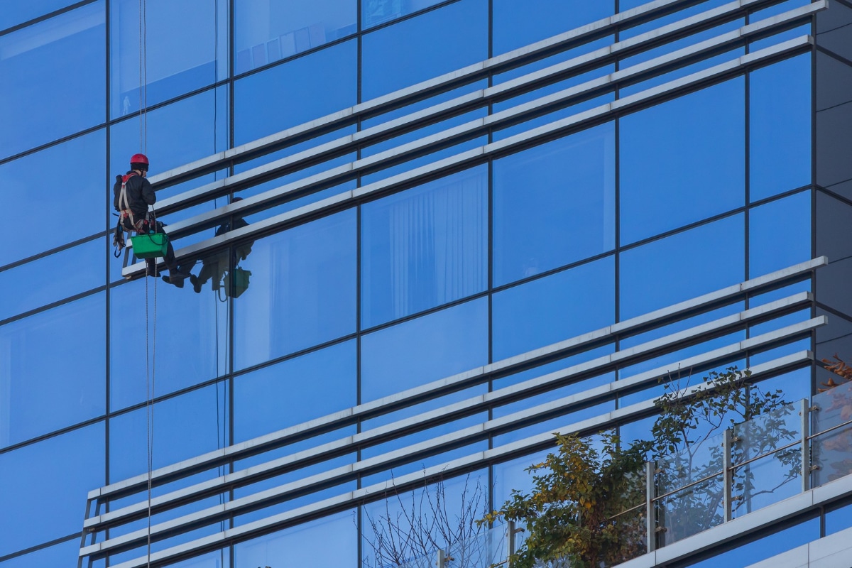 hombre limpiando ventanas en un edificio de gran altura