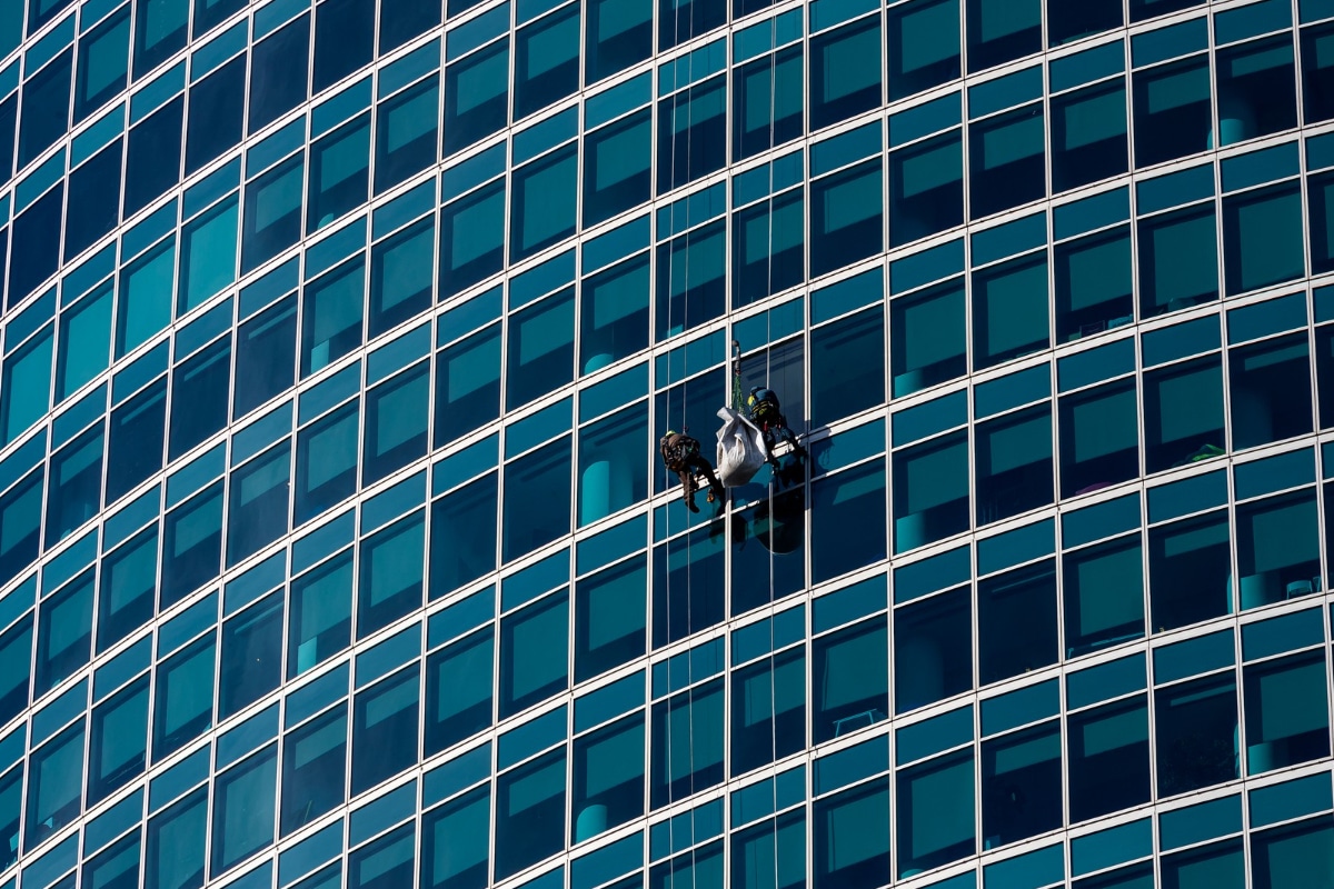 hombre limpiando ventanas en un edificio de gran altura